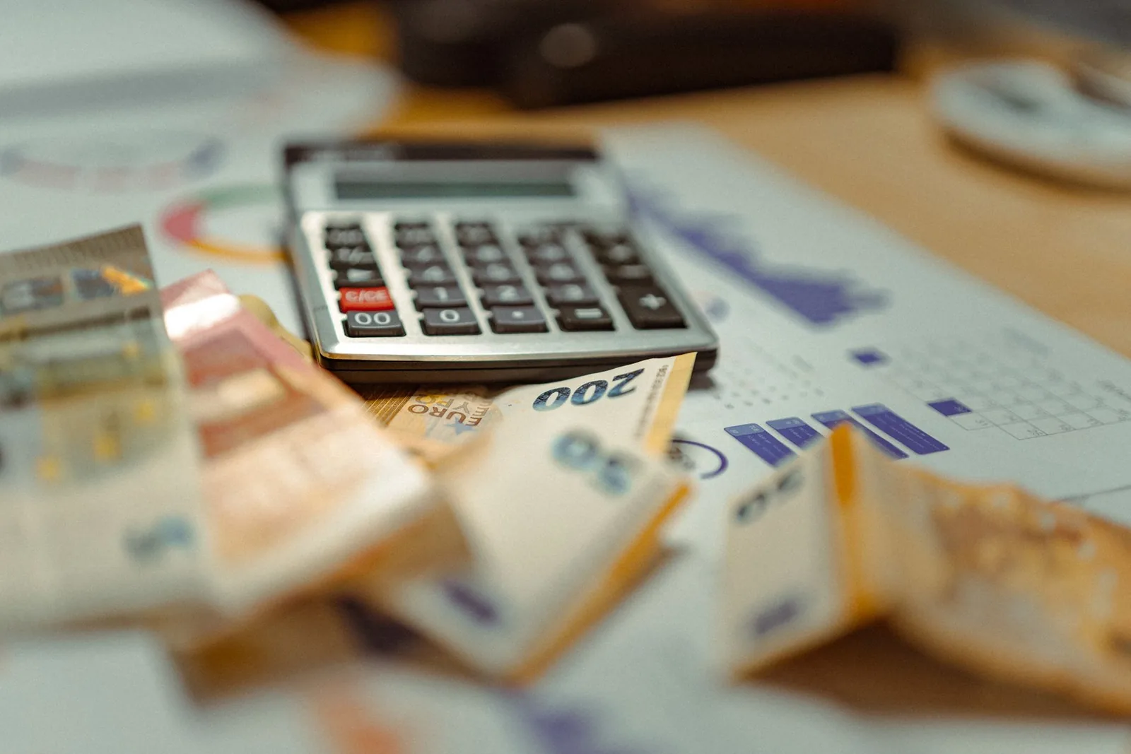 Billets en euros et calculatrice posés sur des documents de paie
