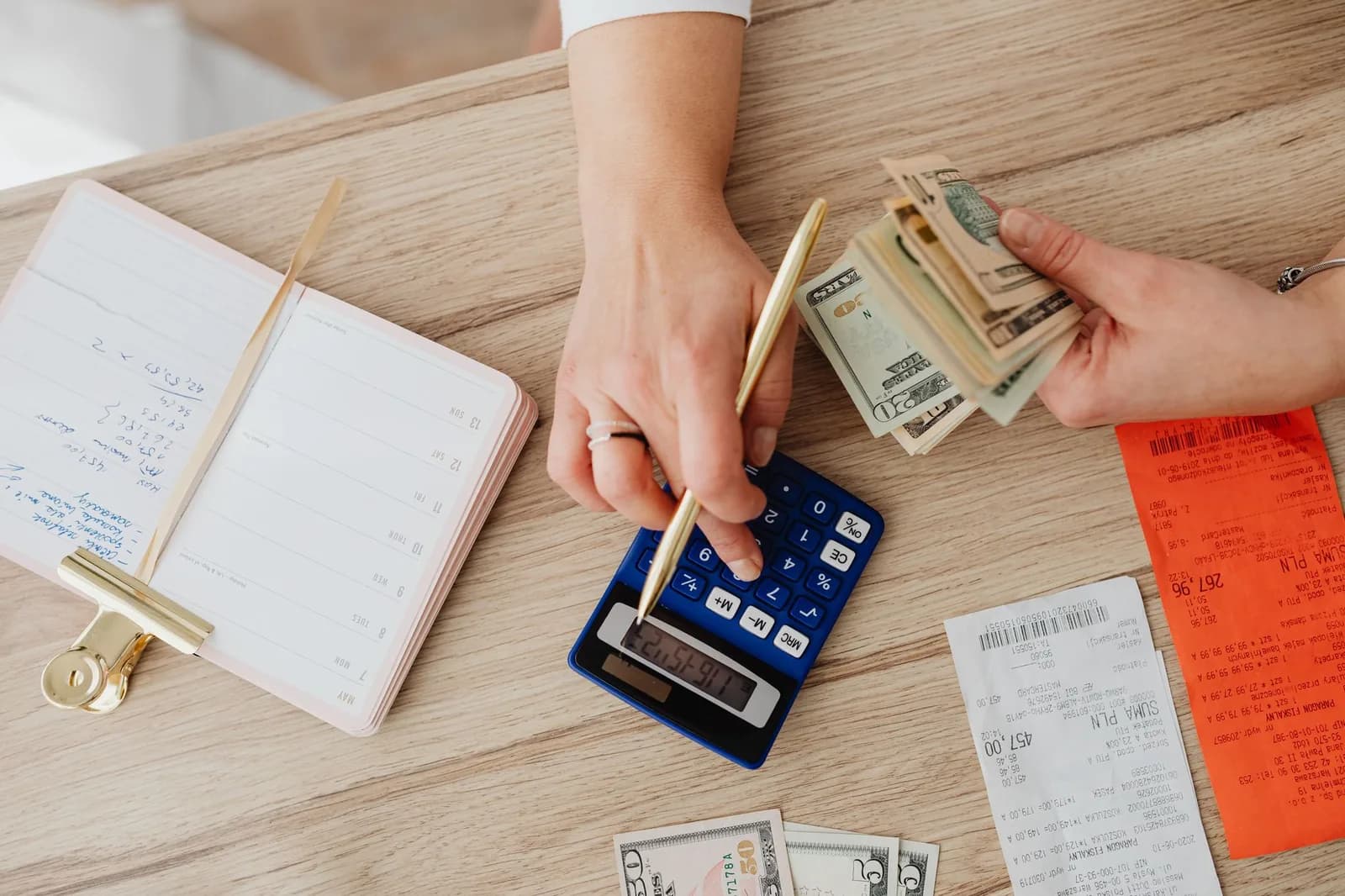 Calcul du budget du mois avec calculatrice, carnet et tickets de caisse