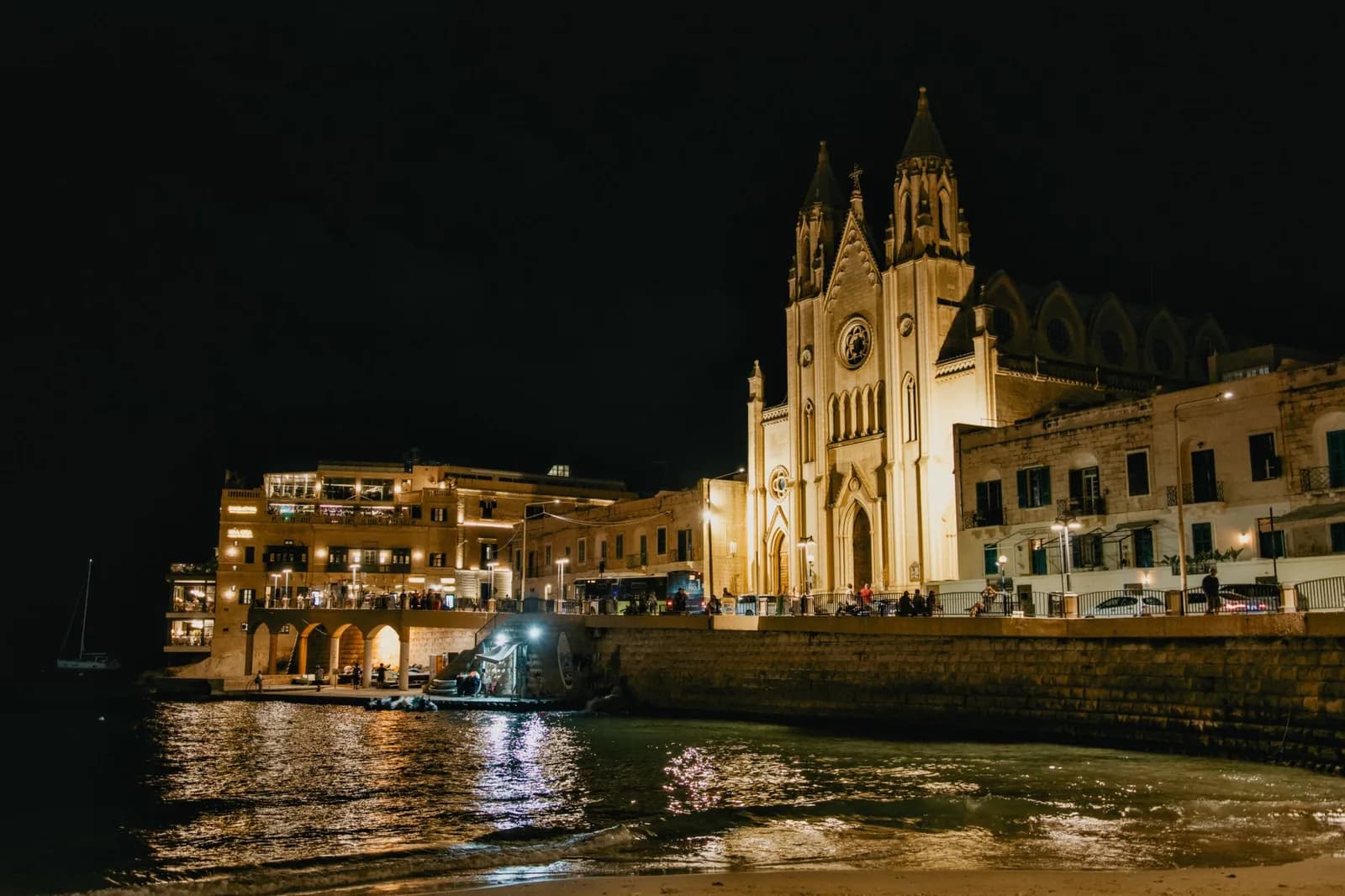 Baie de Balluta à St Julian's, Malte, de nuit : église carmélite et façades éclairées se reflétant dans l'eau