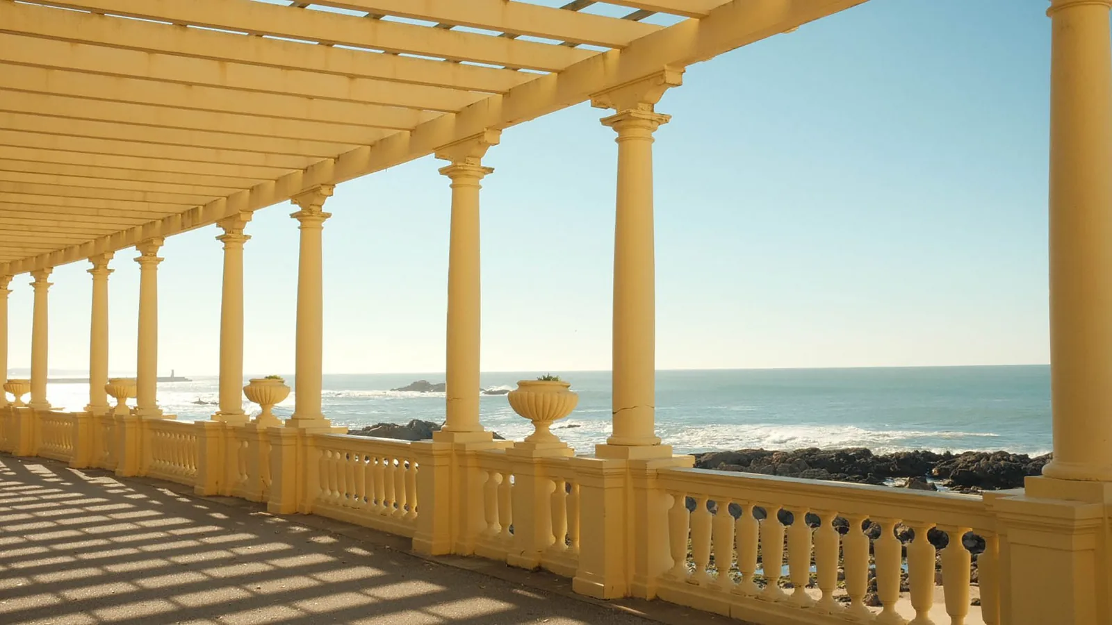 Colonnade en bord de mer baignée de soleil ouvrant sur la Méditerranée