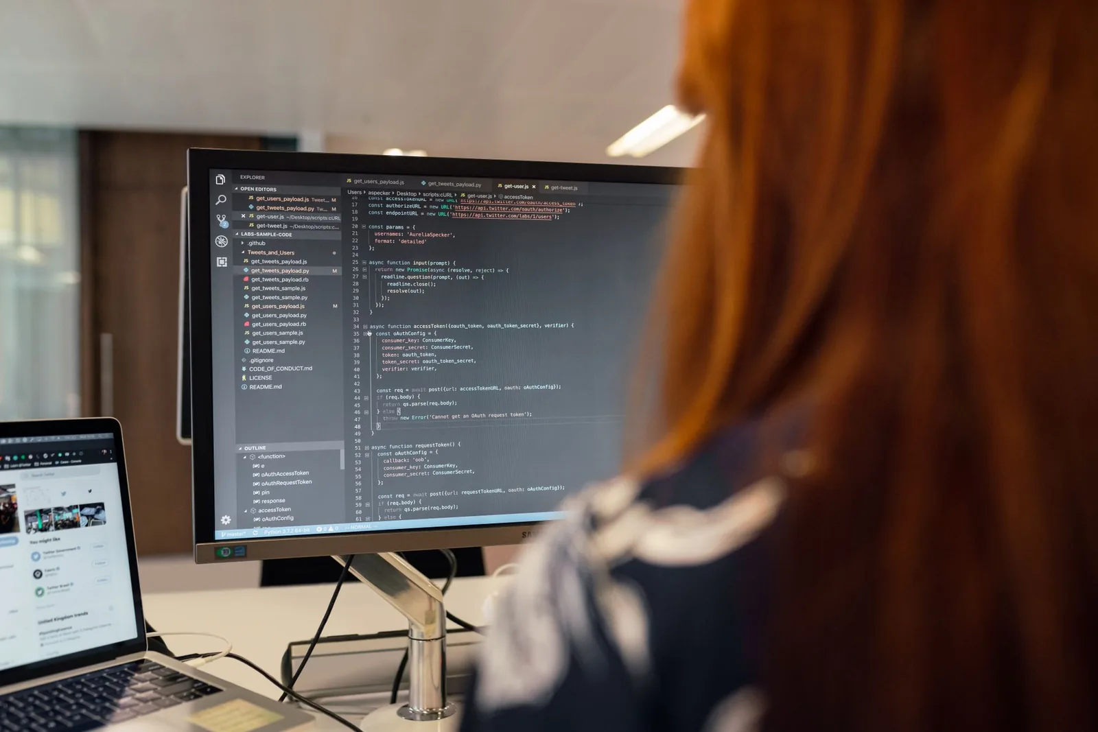 Développeuse devant un écran de code dans un bureau tech