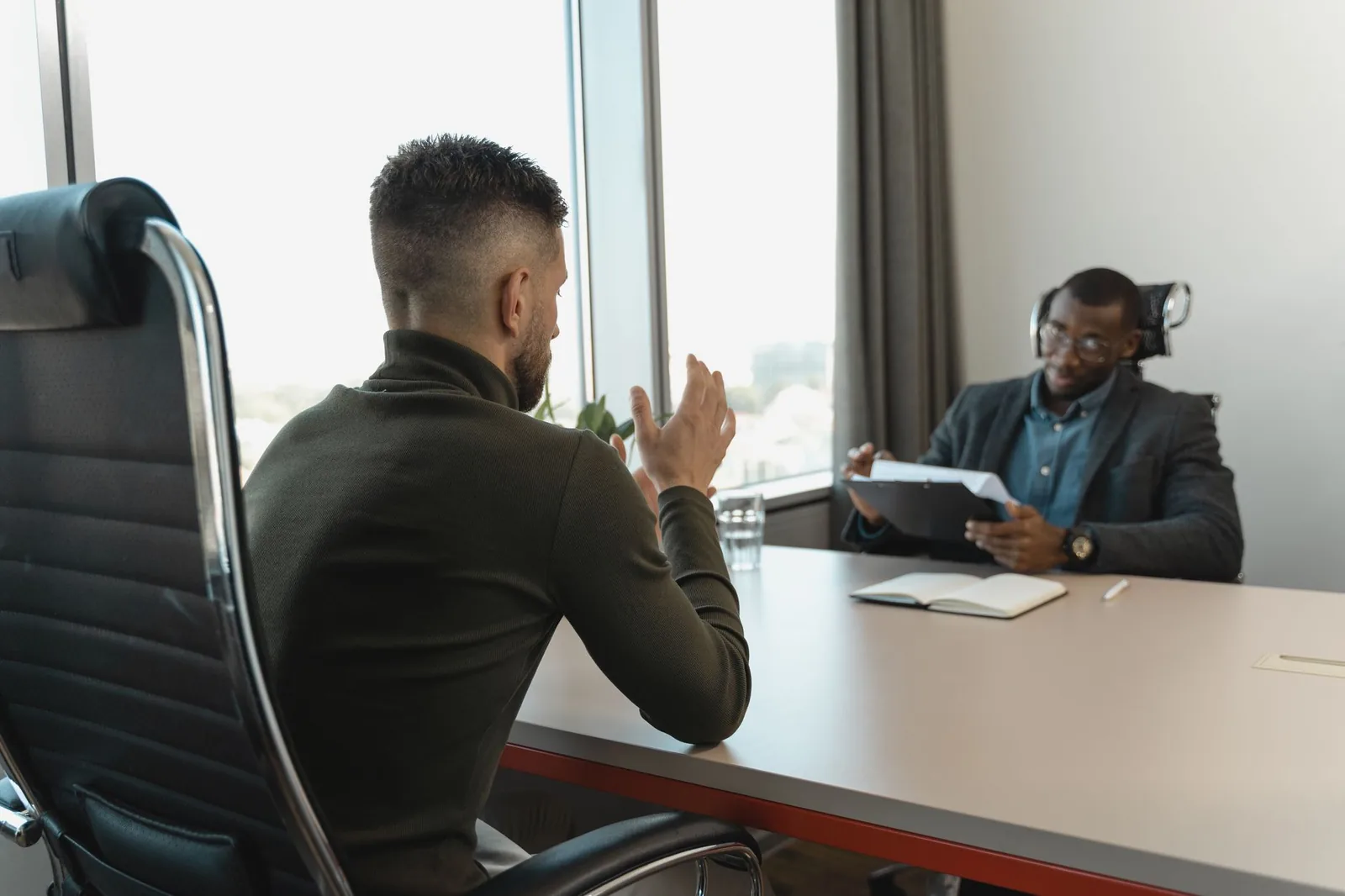 Entretien d'embauche entre un candidat et un recruteur dans une salle de réunion