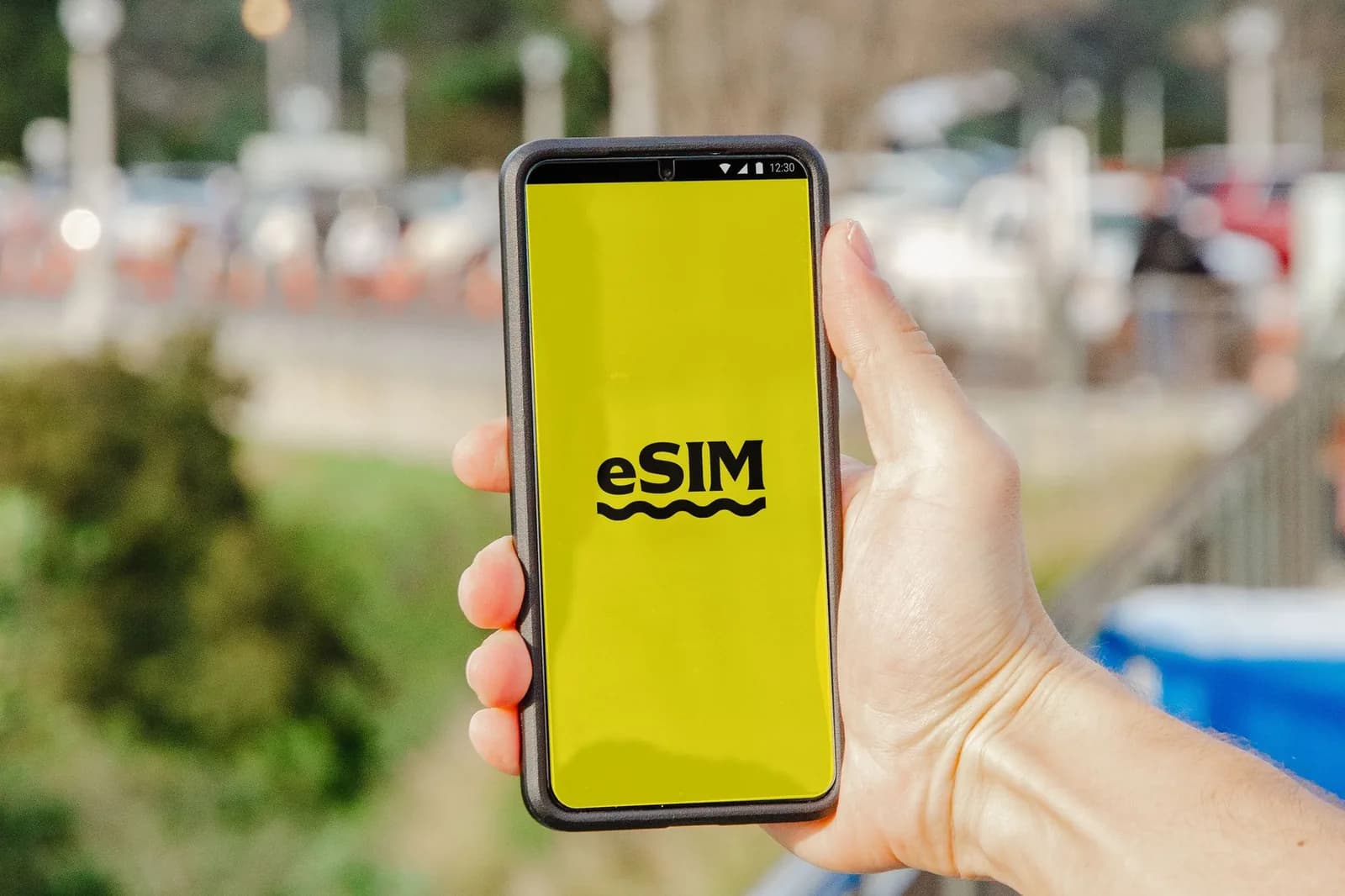 Voyageur tenant un smartphone affichant l'activation d'une eSIM en arrivant à destination
