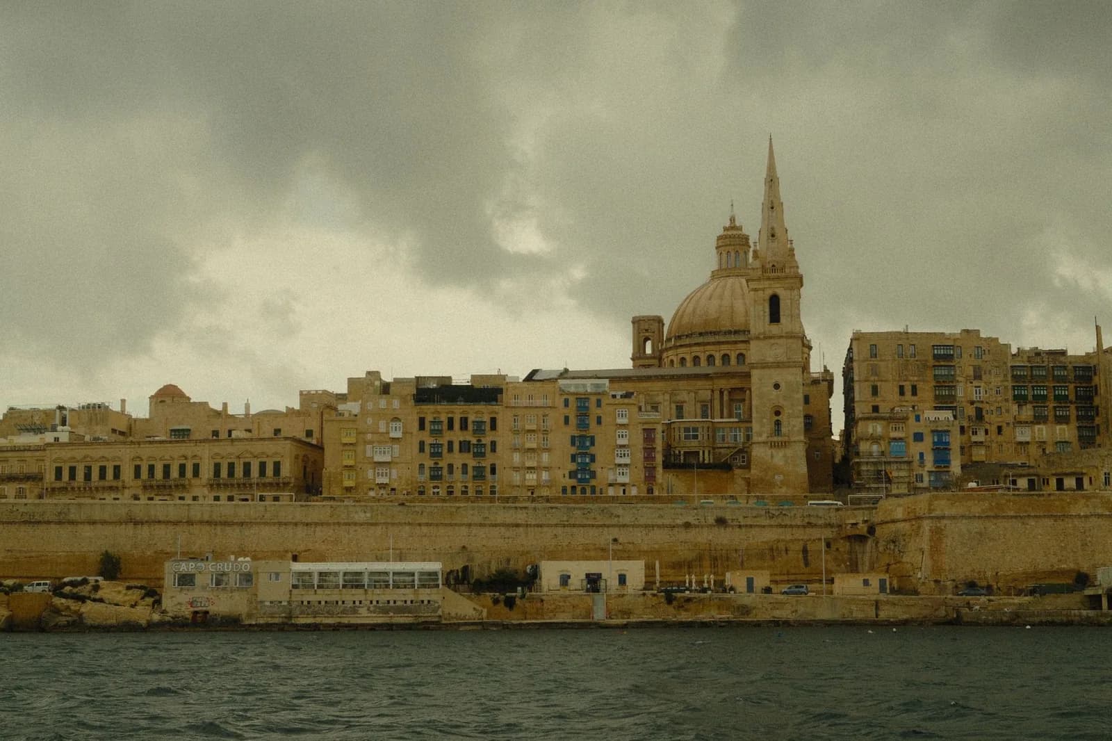 La Valette sous un ciel d'hiver chargé, vue depuis la mer, avec le dôme des Carmélites et le clocher de la cathédrale anglicane Saint-Paul
