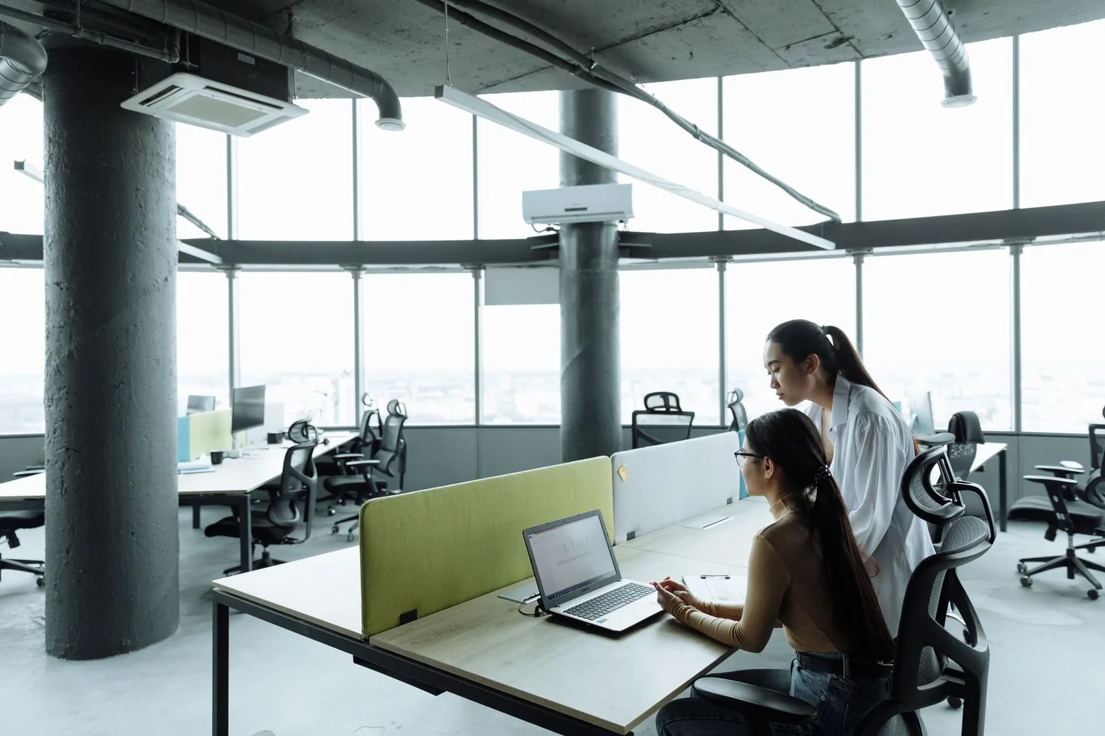 Deux collègues au travail dans un open space vitré