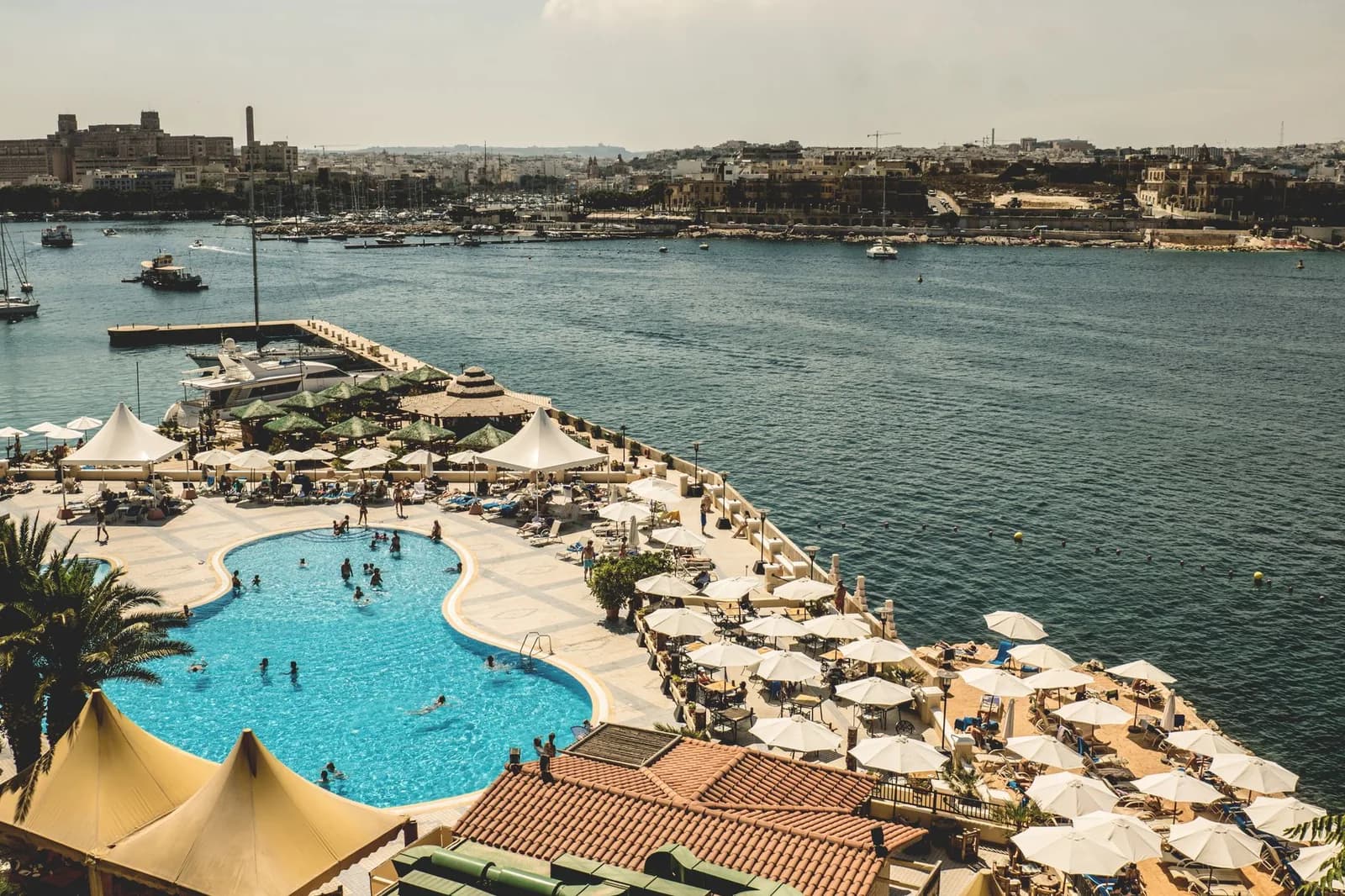 Piscine et transats d'un hôtel-resort au bord du port de Marsamxett, face à Sliema, à Malte