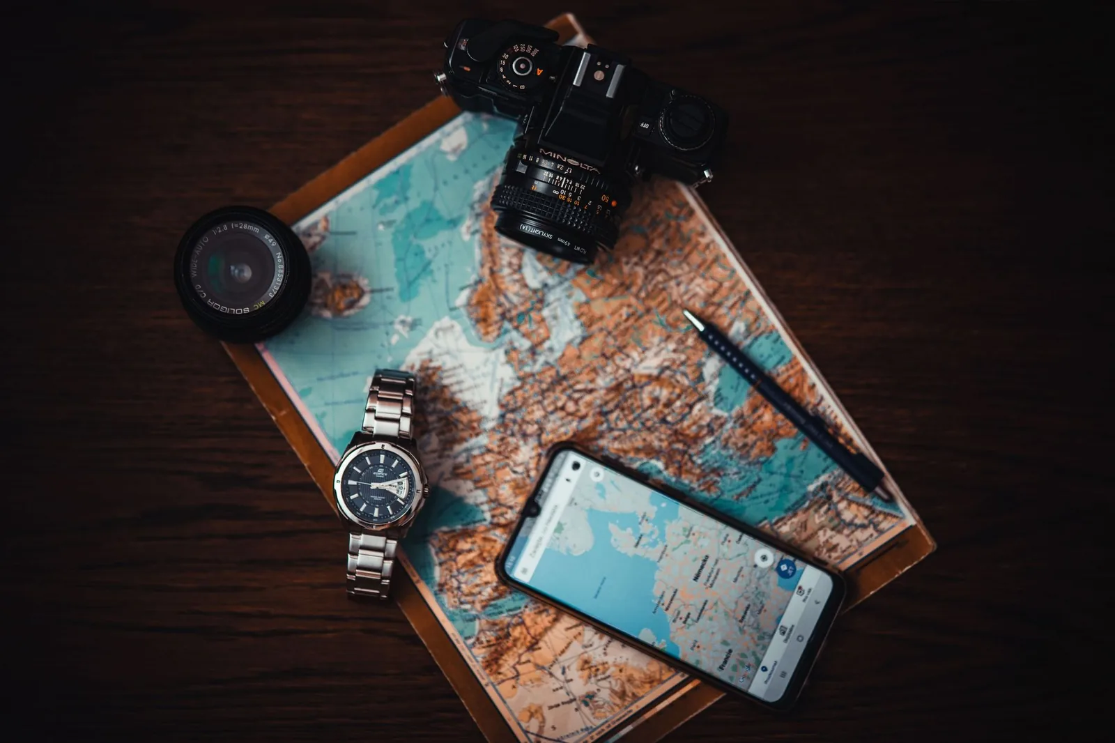 Carte de la Méditerranée, appareil photo et téléphone posés sur une table pour préparer un séjour à Malte