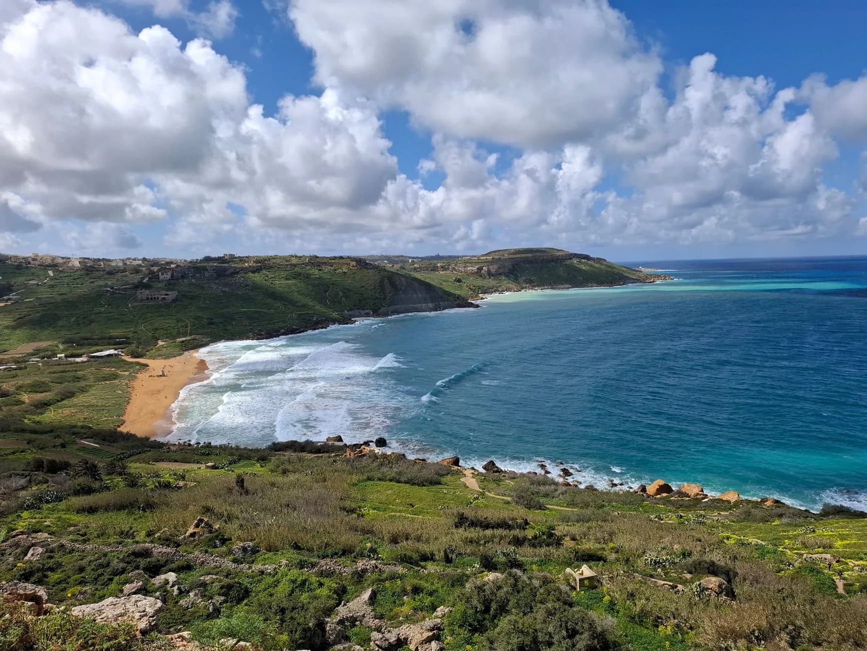 Vue en hauteur de la baie de Ramla à Gozo (Malte), sa plage de sable orangé bordée de collines vertes et de la mer turquoise