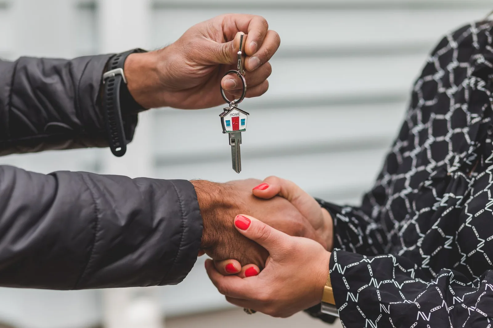 Remise des clés d'un logement à un acheteur devant la maison