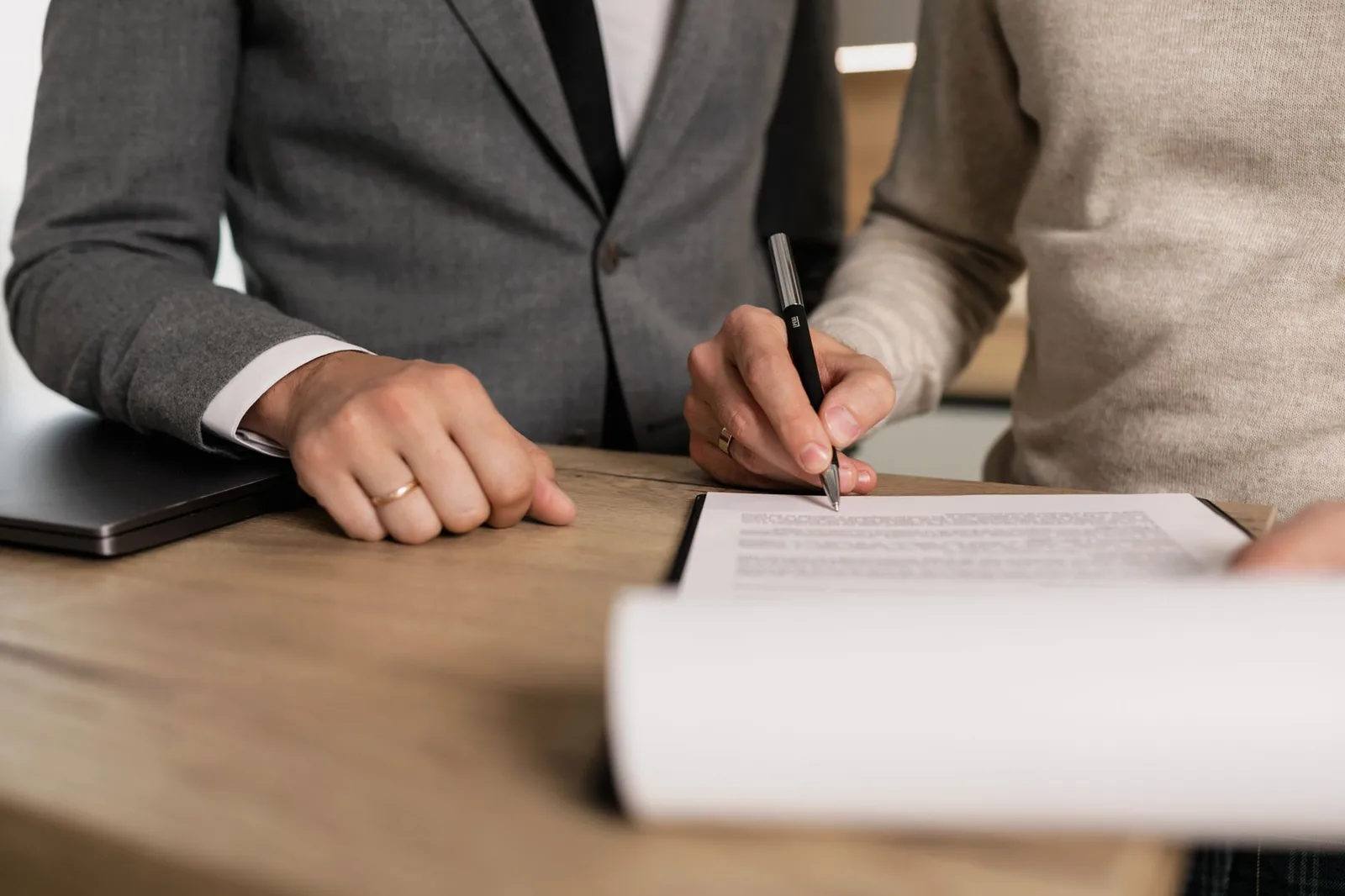 Signature d'un accord écrit entre deux personnes autour d'une table de réunion