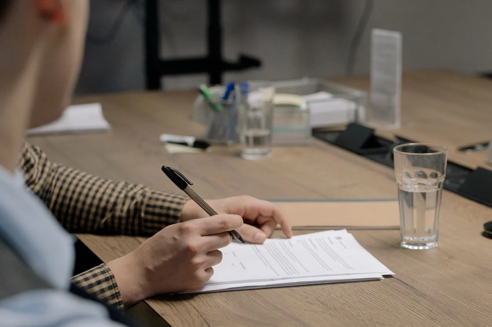 Signature de documents administratifs sur un bureau en bois