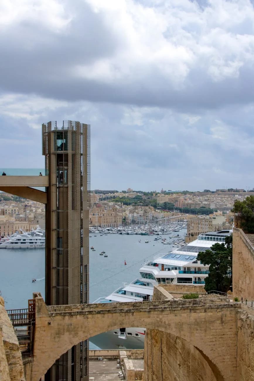 L'ascenseur Barrakka, tour moderne contre les remparts de La Valette, avec le Grand Harbour et un bateau de croisière derrière