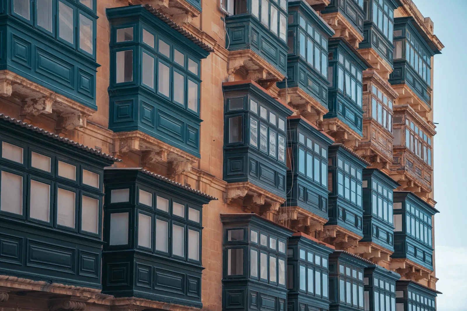 Façade en pierre calcaire et gallarija, les balcons fermés en bois traditionnels de Malte, typiques des biens de caractère vendus dans les centres anciens