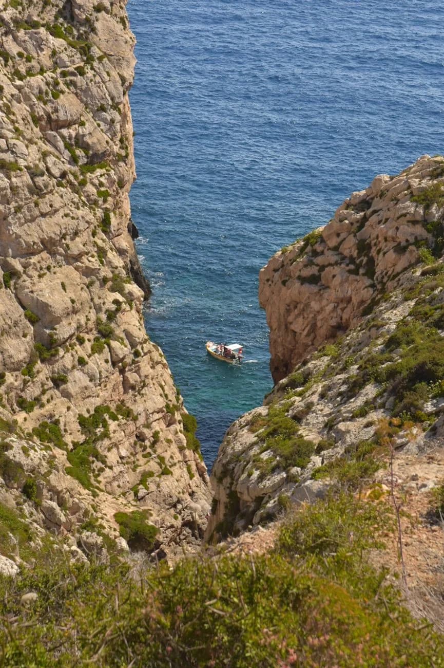Barque de touristes entre les falaises de Wied iż-Żurrieq, à la Grotte Bleue de Malte