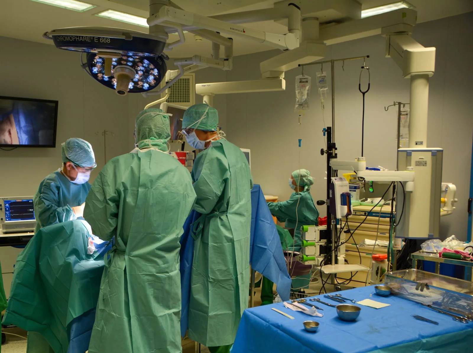 Équipe chirurgicale au travail dans un bloc opératoire d'hôpital public équipé