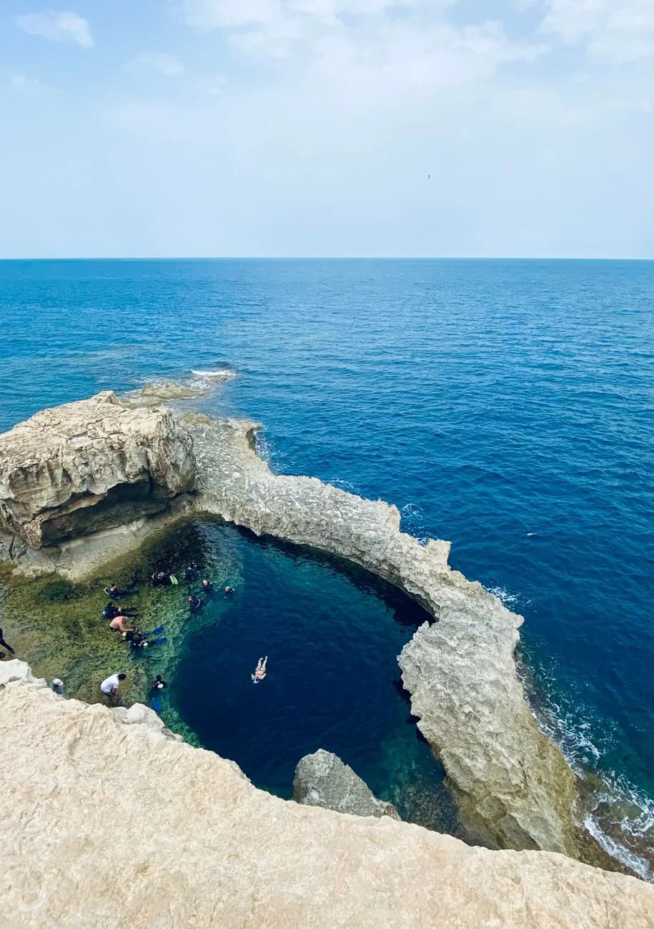 Le Blue Hole de Dwejra à Gozo vu du haut de la falaise, avec des plongeurs qui s'équipent au bord du bassin