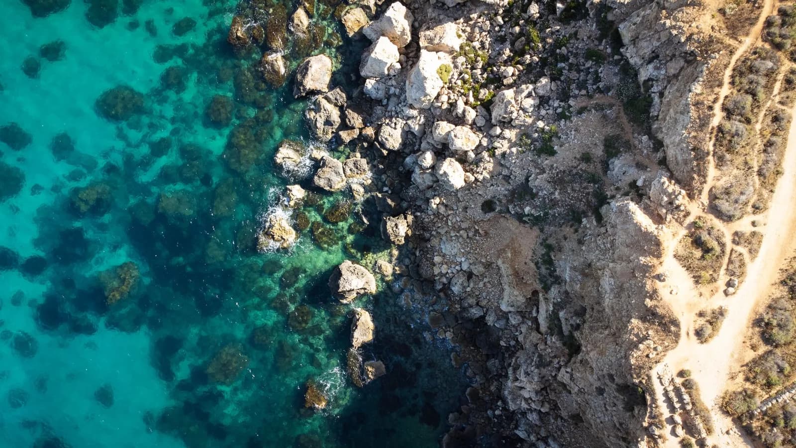 Côte rocheuse et eau turquoise à Malte, vue aérienne d'une crique typique de l'archipel