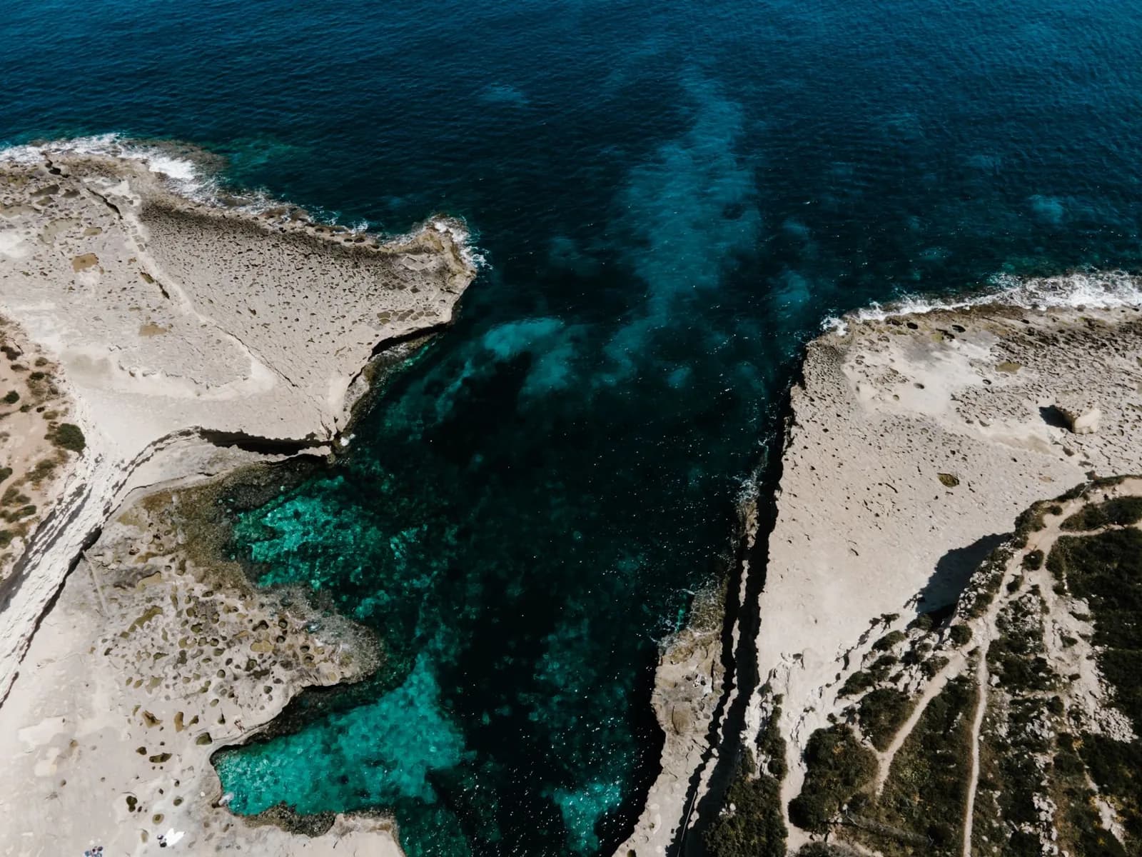 Crique rocheuse aux eaux turquoise et terrasses de calcaire blanc sur la côte sud de Malte, vue aérienne