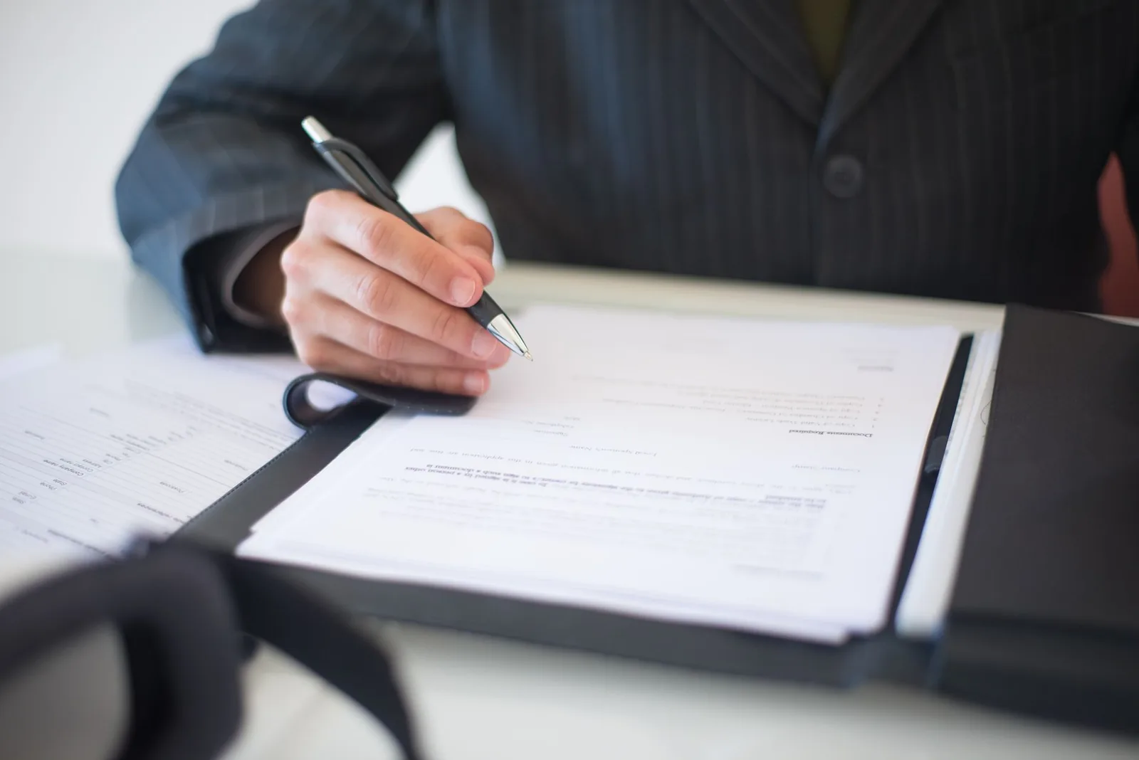 Personne remplissant un formulaire d'ouverture de compte bancaire avec la liste des documents requis