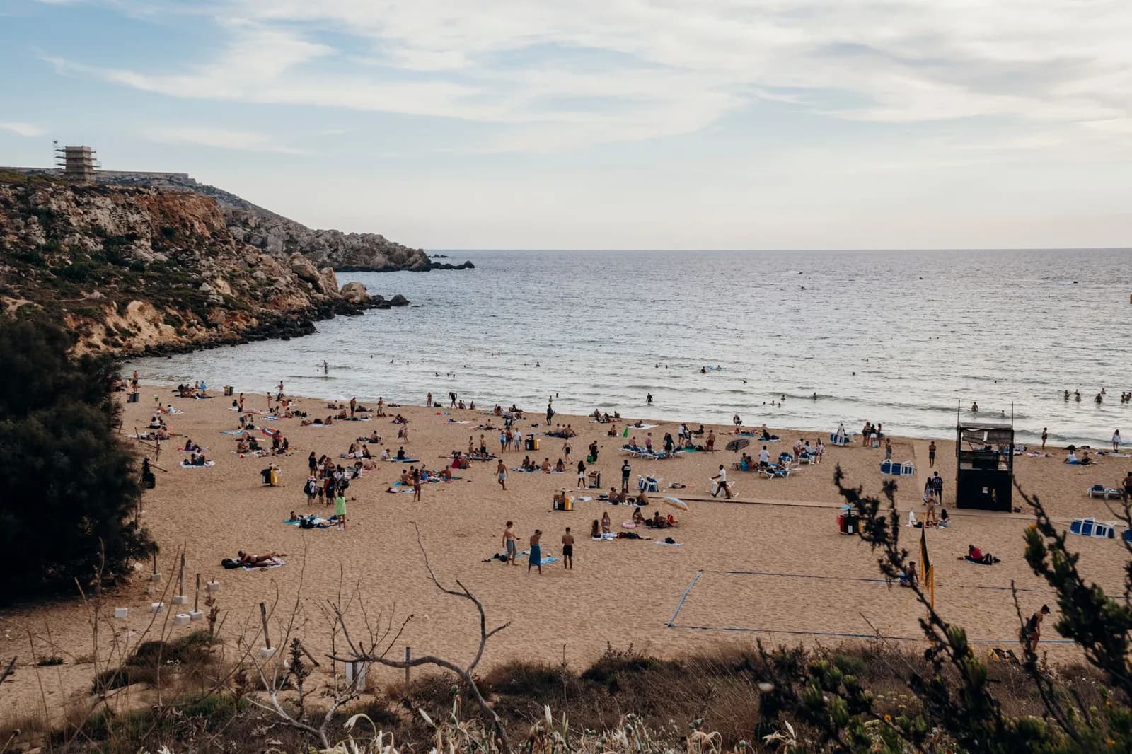 Golden Bay bondée au nord de Malte en pleine saison estivale, baigneurs et transats sur le sable