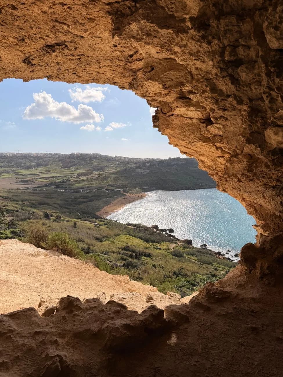 Depuis la grotte Tal-Mixta à Gozo (Malte), l'ouverture de la roche cadre la baie de Ramla et sa plage