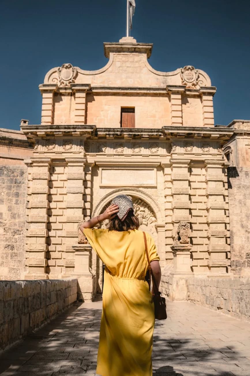 Visiteuse seule devant la porte principale de Mdina, la cité fortifiée du centre de Malte