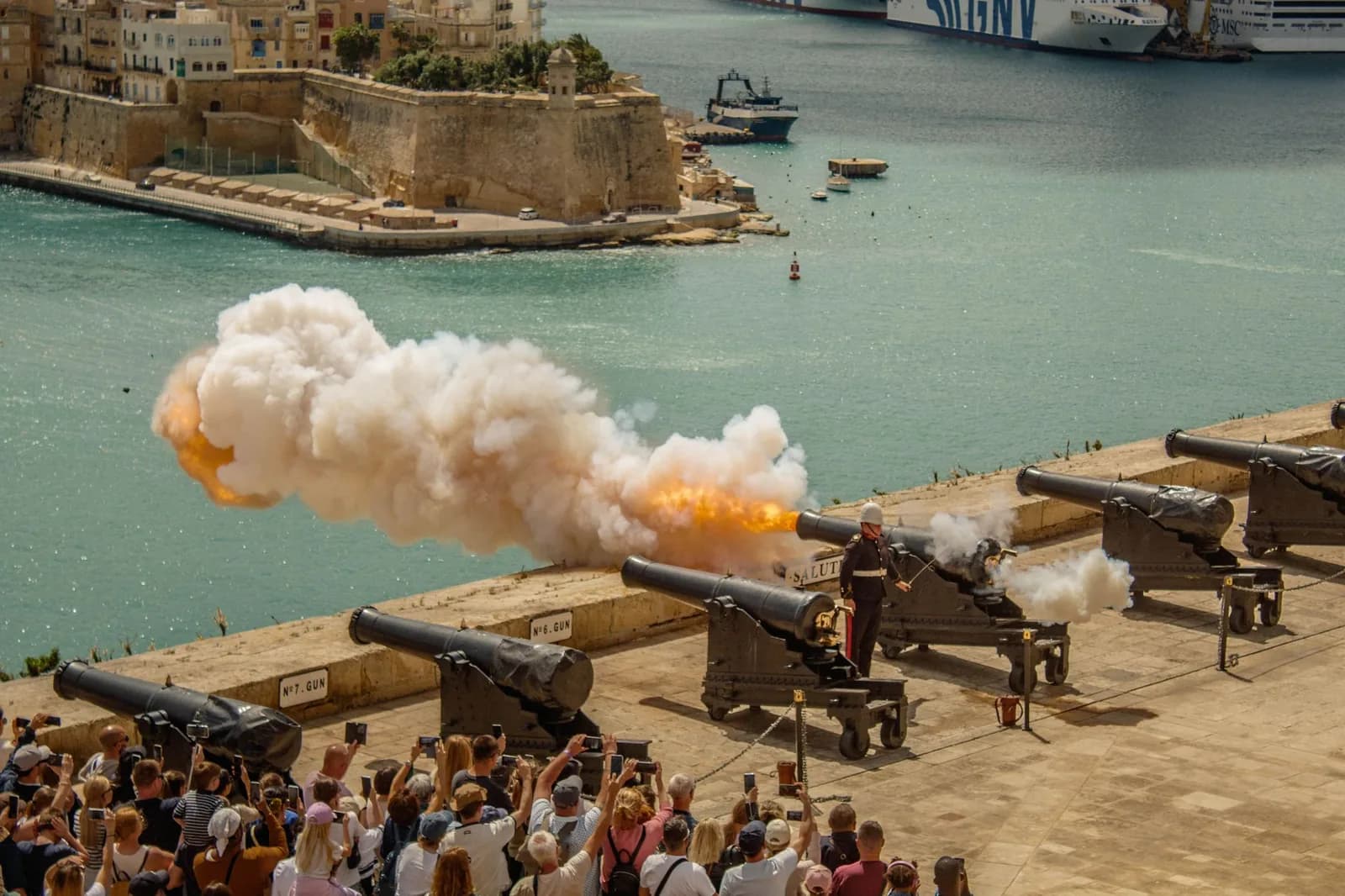 Tir de canon de la Saluting Battery à La Valette, fumée blanche et foule face au Grand Harbour