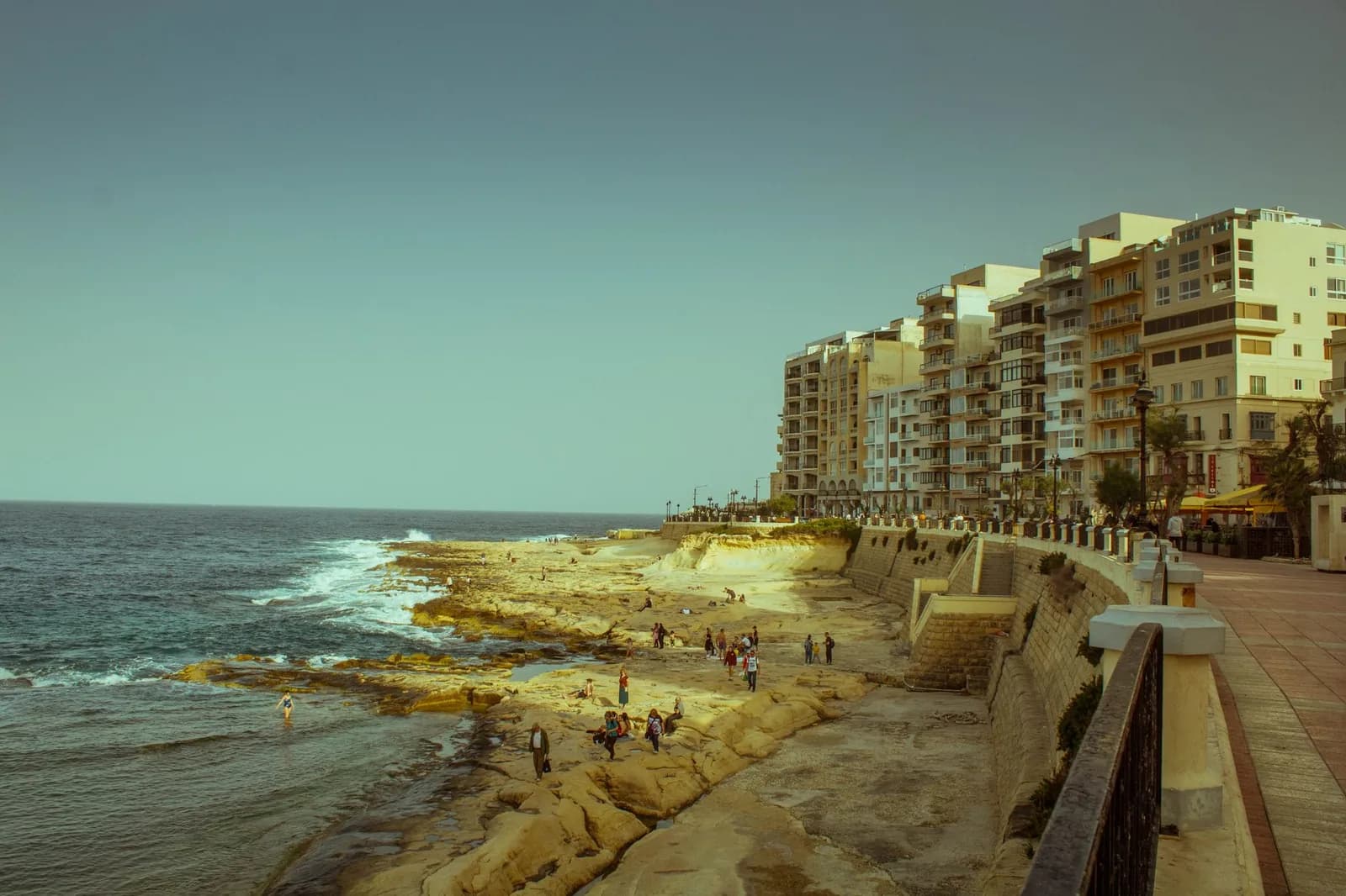Front de mer de Sliema à Malte avec sa promenade, ses rochers plats et ses immeubles résidentiels en bord de côte