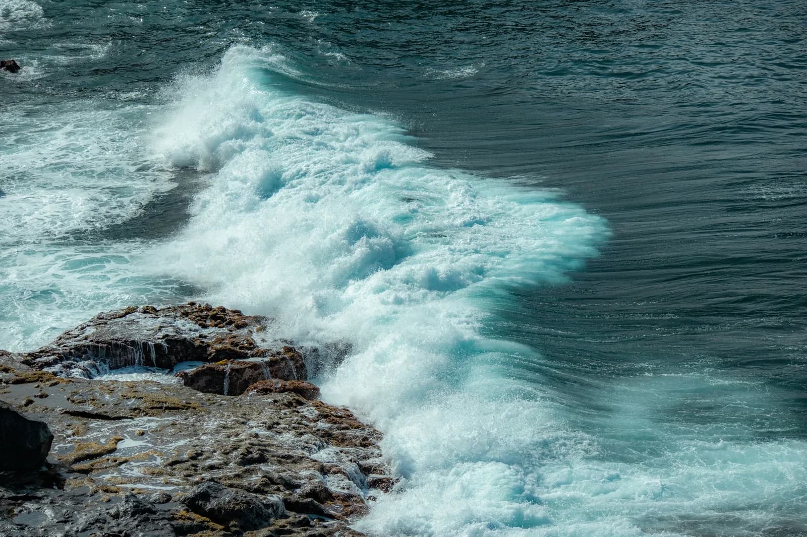 Vague qui s'écrase sur une côte rocheuse de Malte, mer agitée et sombre